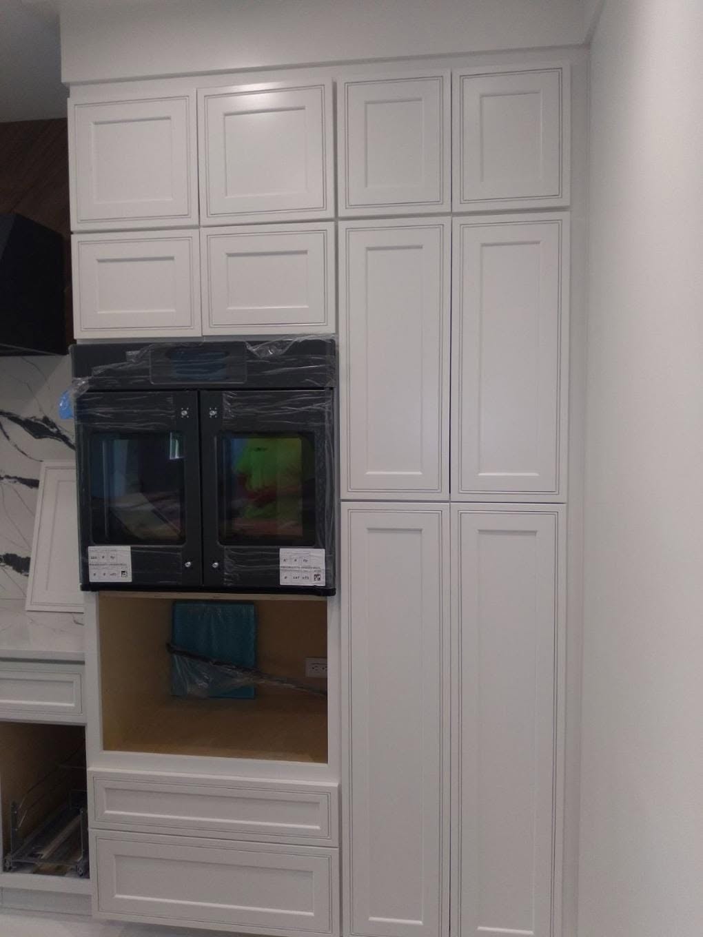 Finished custom shaker kitchen cabinets with factory-smooth white spray coating and double oven built-ins in Naples