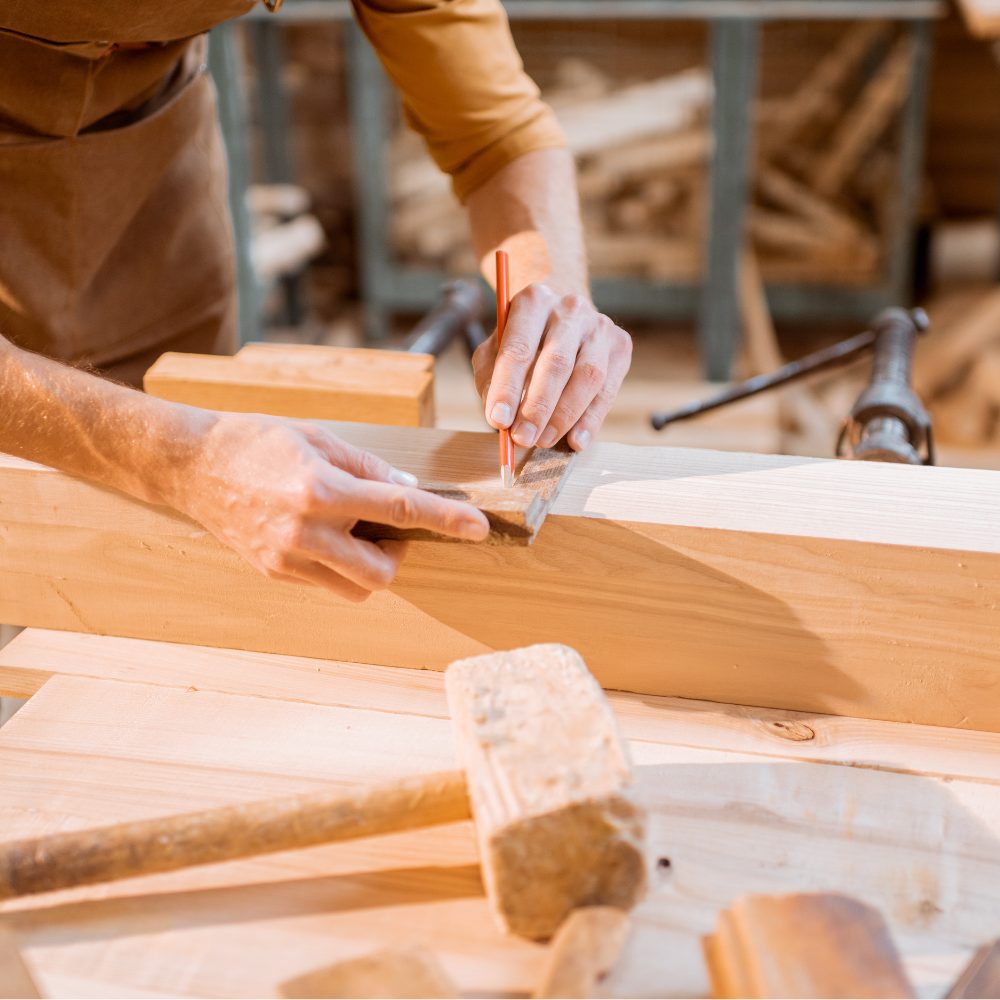 Carpenter marking a measurement on timber