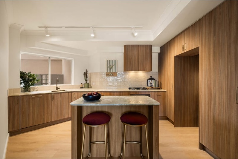 Surry Hills kitchen after renovation, warm timber cabinetry and stone island