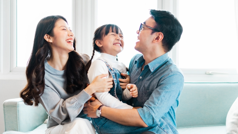 Filipino family laughing and cuddling together at home