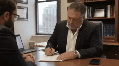 An attorney signing a retainer and shaking hands with a client