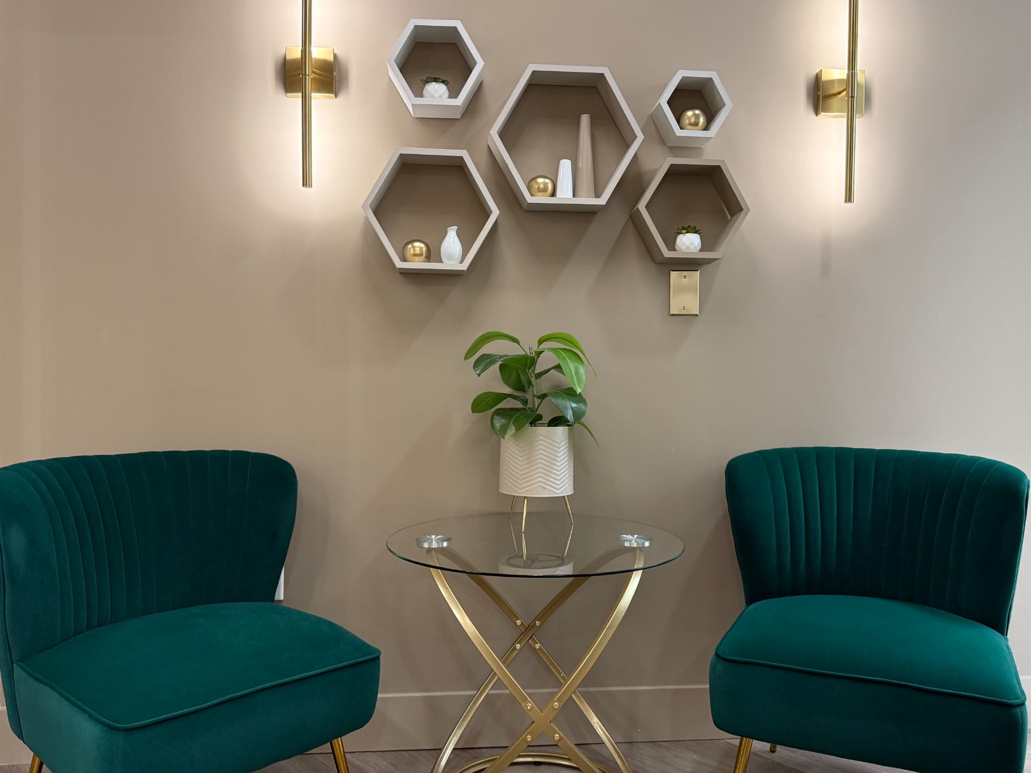 Client relaxation lounge with emerald green velvet seating at ReNuMED Aesthetics