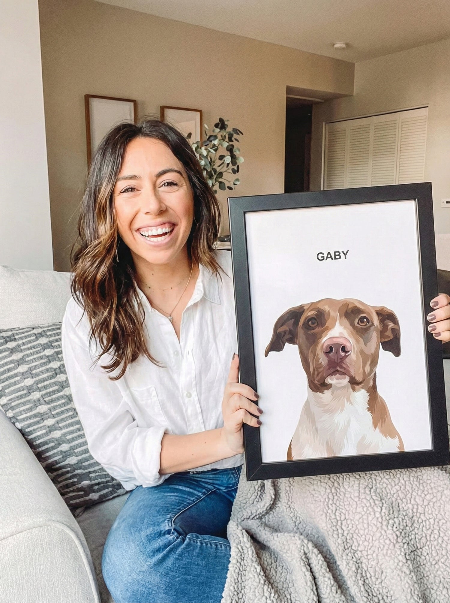 Joven sonriente en su sala con su mascota y el retrato FIRMACH