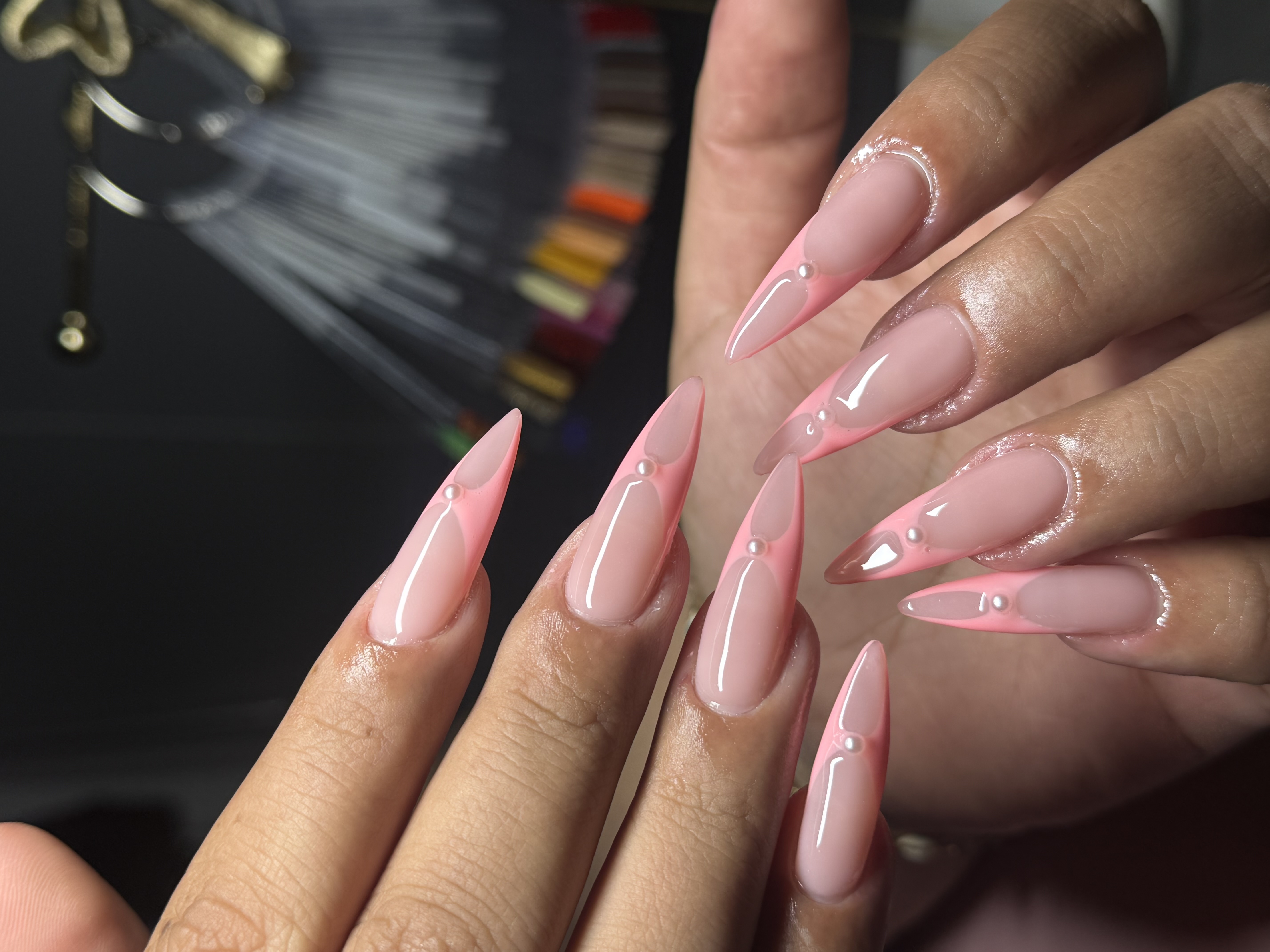 Long sculpted stiletto acrylics with soft pink french tip and pearl embellishments