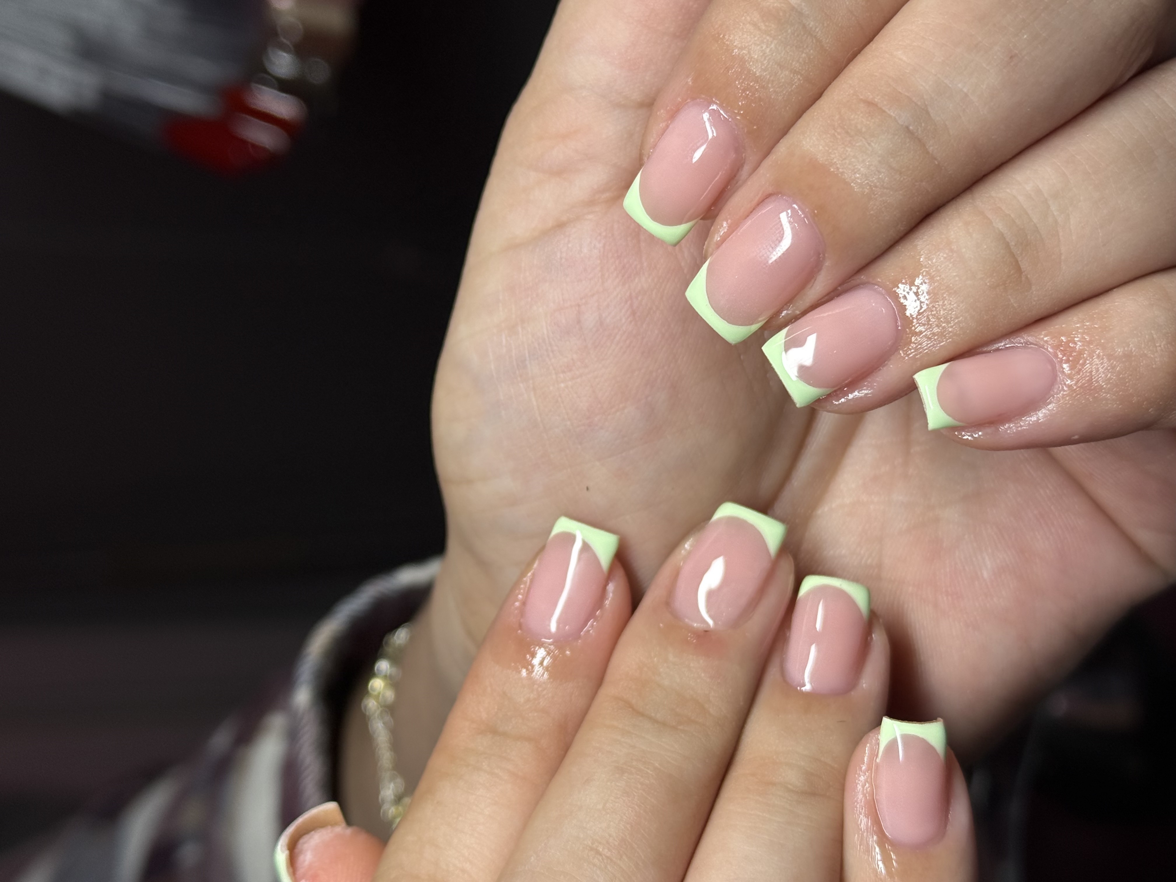 Clean square natural nails with pastel mint lime green french tips and high-gloss nude base