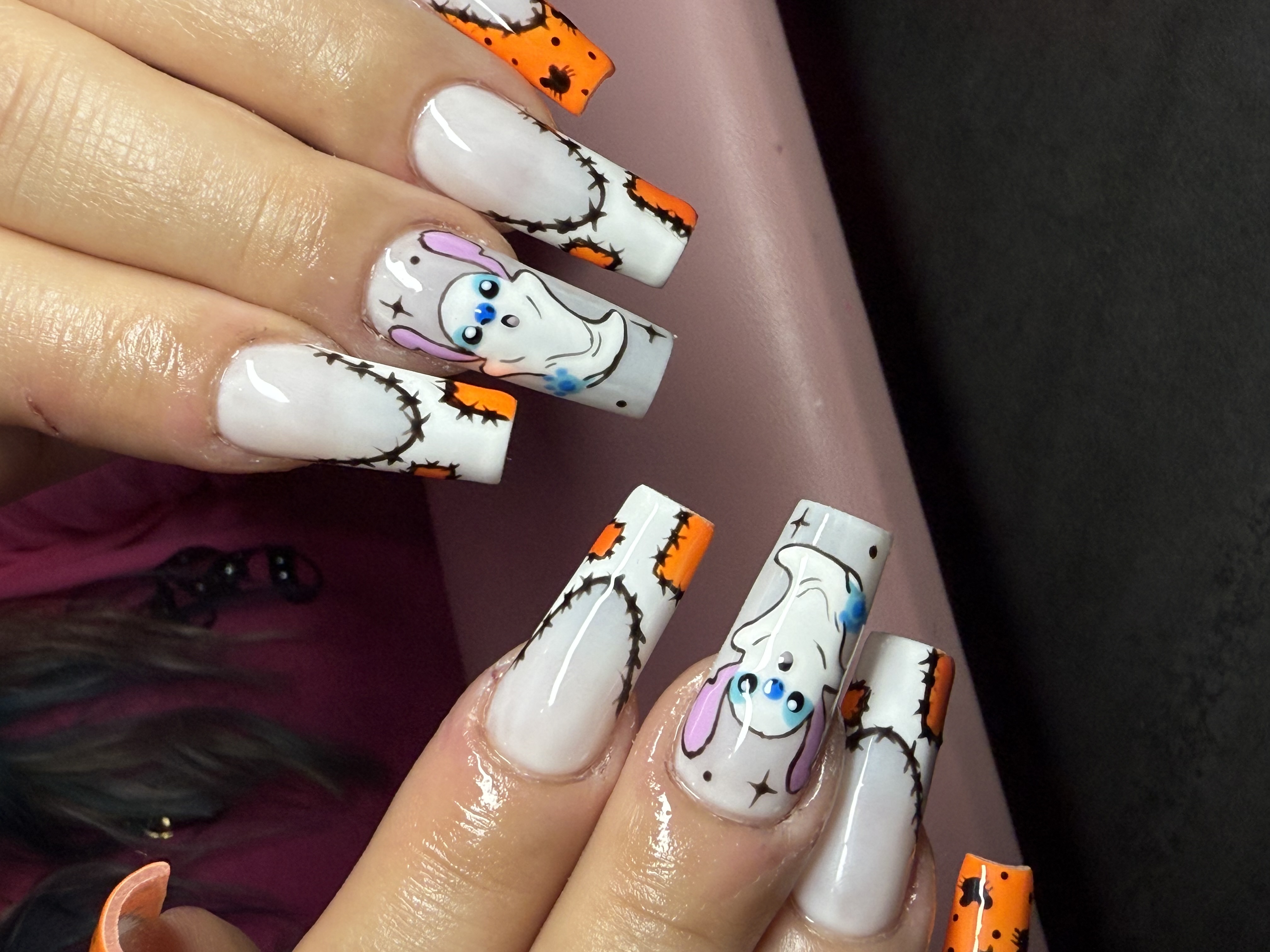 Long square ghost themed nails with barbed wire framing and orange spiderweb accents