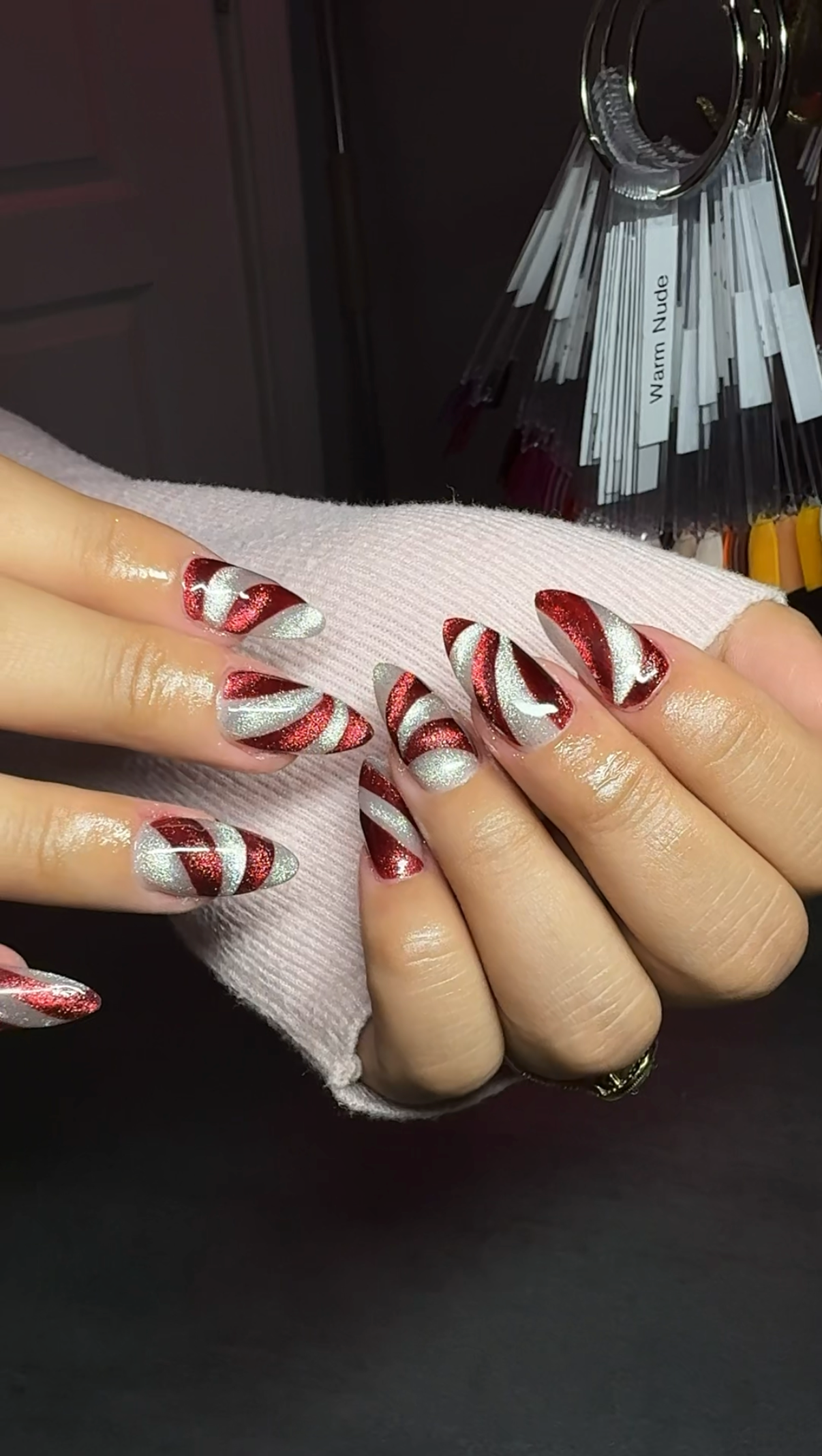 Stiletto nails with metallic crimson and glittery silver candy cane swirls