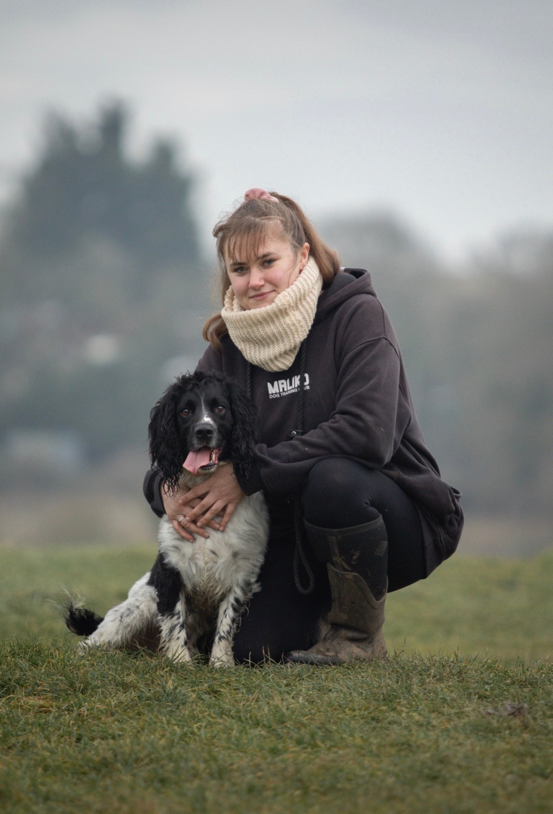 Jess kneeling with dog outdoors