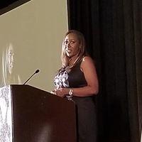 Gwendolen Wilder keynote guest speaking at the podium with microphone
