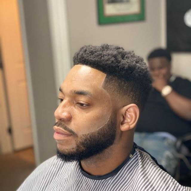 Afro curls with high skin taper, razor edge-up, and crisp beard trim