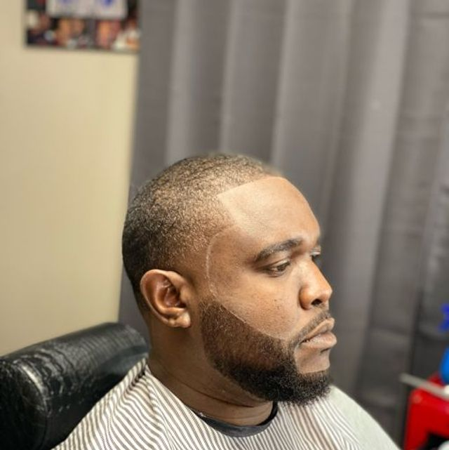 Precision low fade with sharp beard line-up and sculpted facial hair