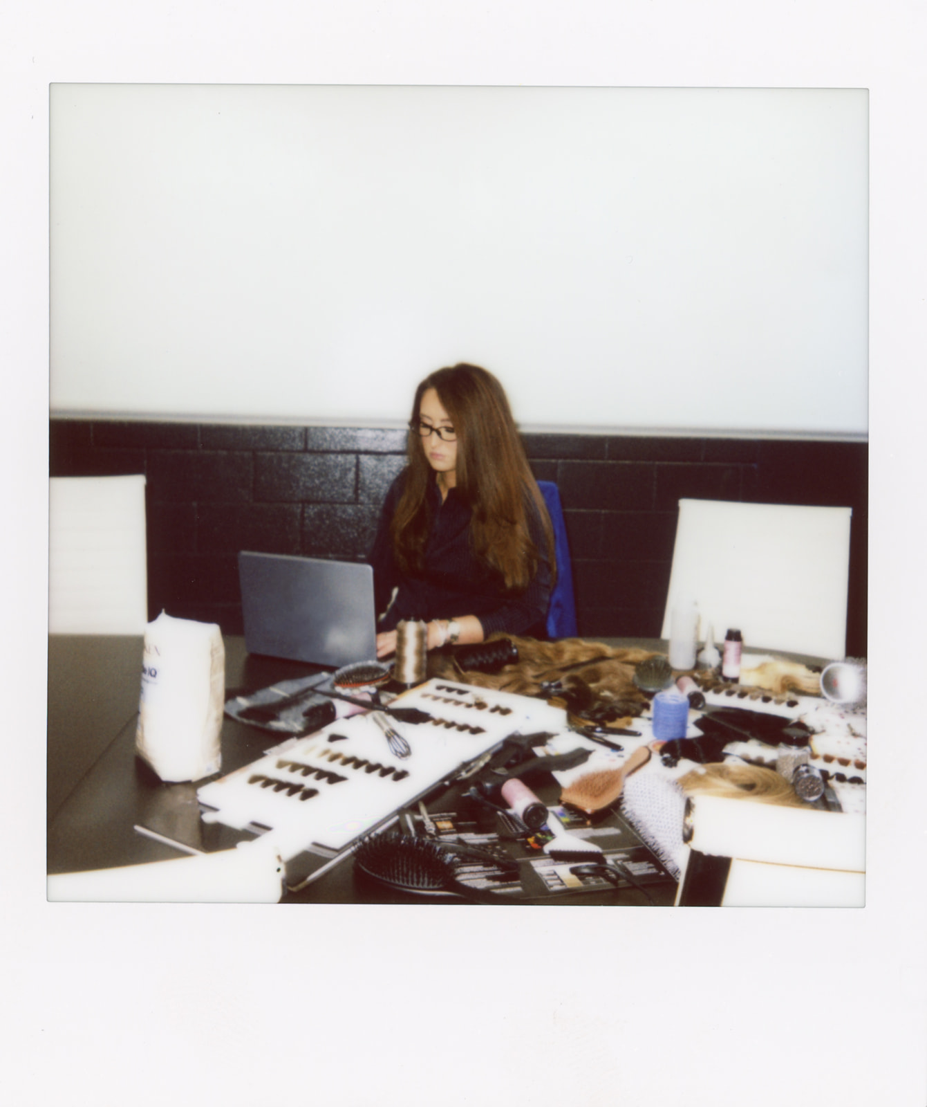 Honest business coach working with client hair swatches and laptop