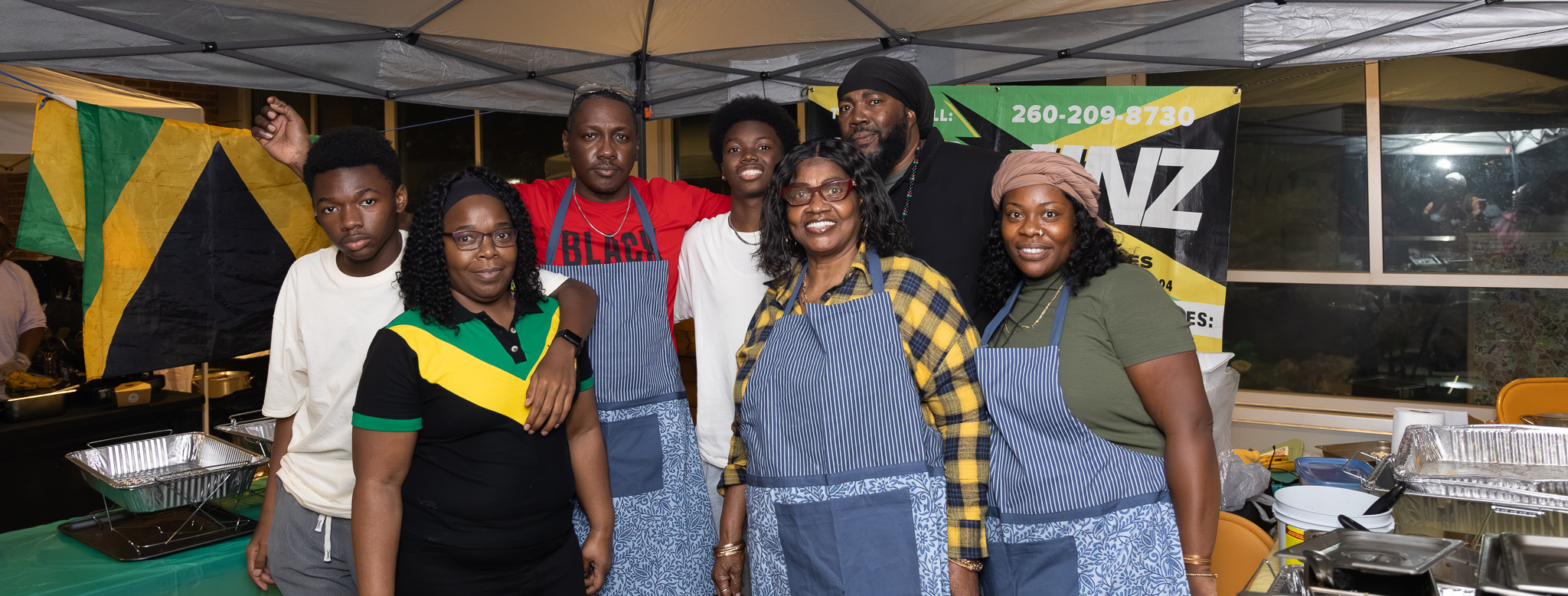 The Nyaminz family team under the catering tent with the Jamaican flag in Fort Wayne
