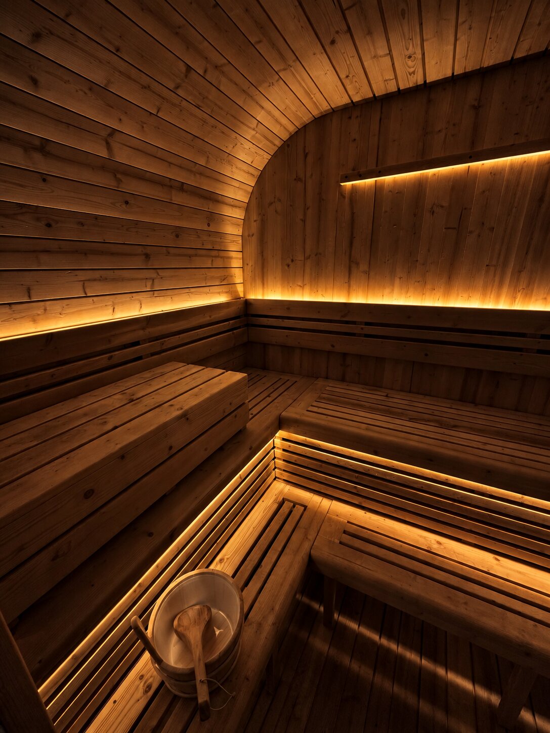 Sauna interior with tiered benches and warm under-bench lighting