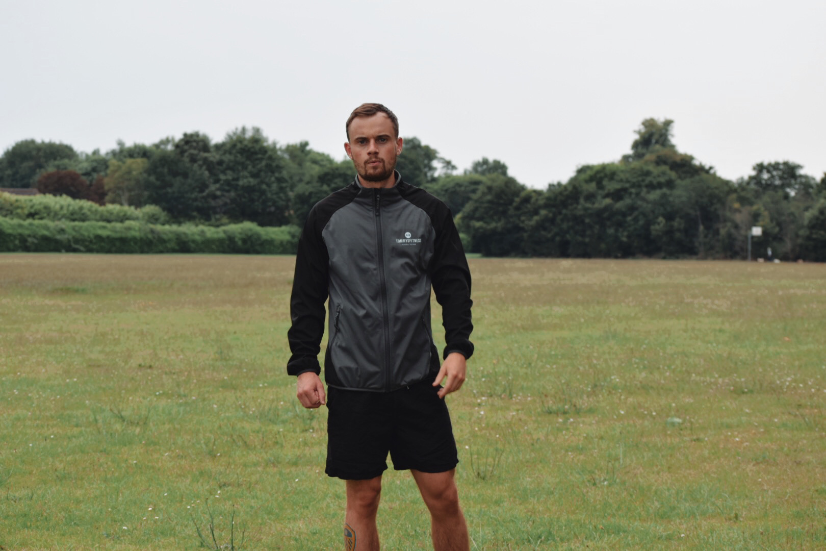 Personal trainer Tommy Rowlands standing on an outdoor park training pitch in Reading in Tommy's Fitness kit
