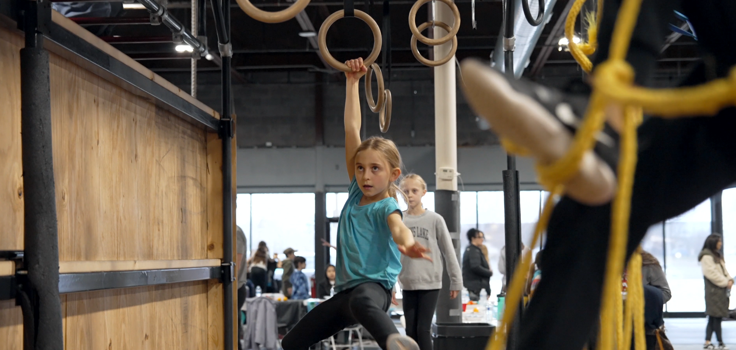 Girl swinging on rings at GRIT summer camp