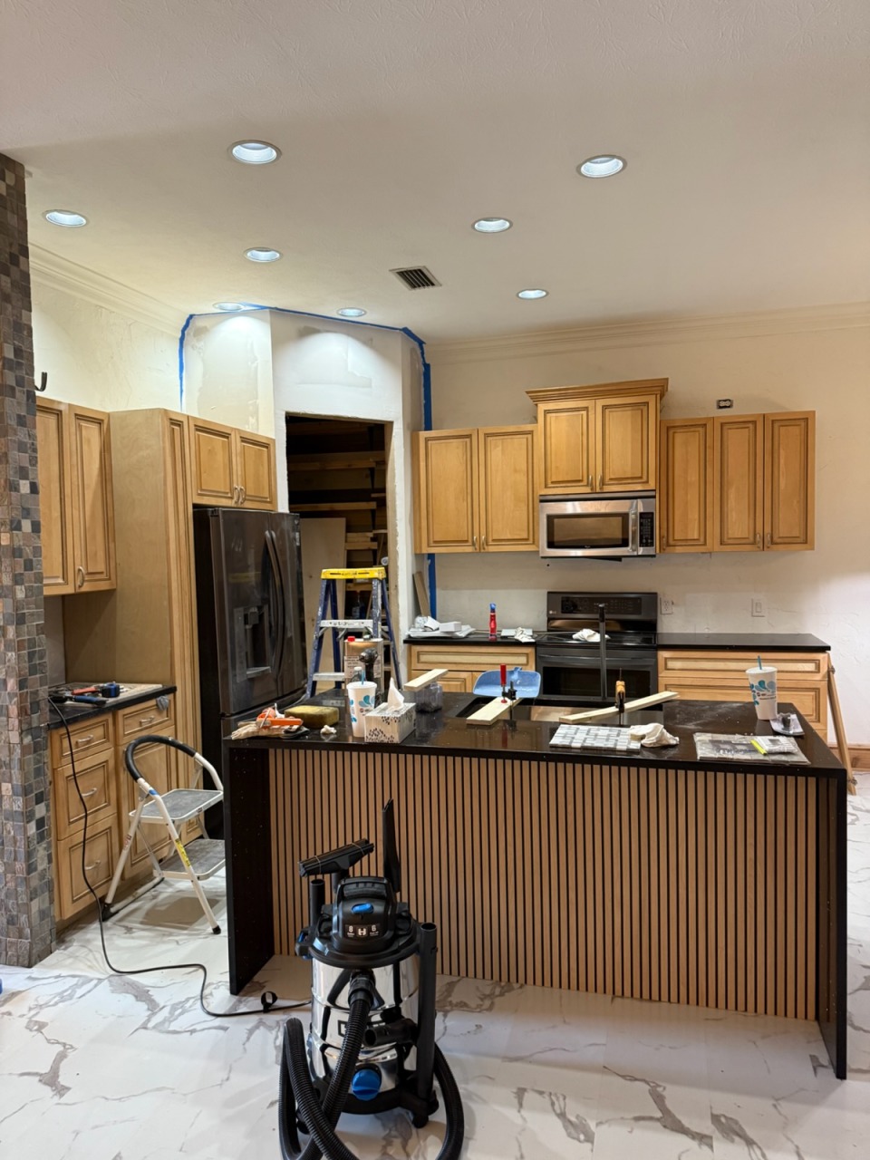 Custom wood slat island and granite fabrication in progress by Abreu Construction