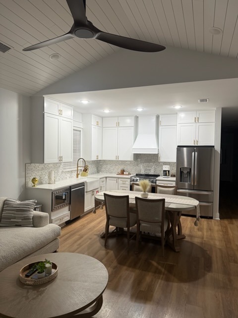 Open-Concept White Shaker Kitchen with Integrated Range Hood & Vaulted Ceiling