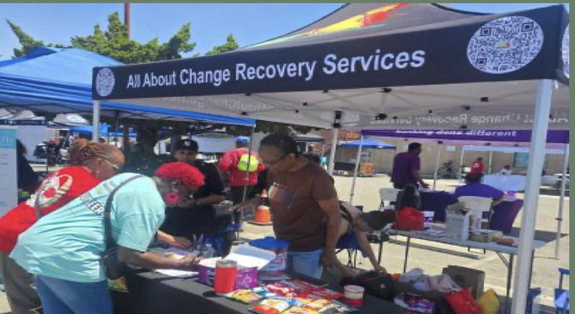 All About Change Recovery Services community outreach booth in Los Angeles with volunteers and resource tables