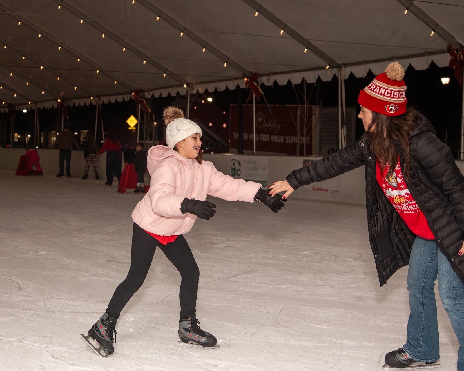Smiling family enjoying ice skating together at Christmas Skate Night