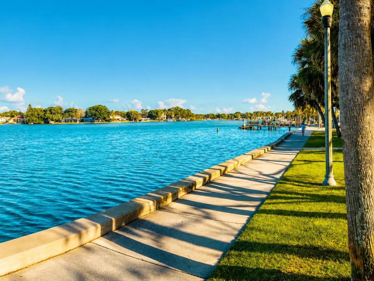 Sunny view along the Coffee Pot Bayou seawall and palm-lined waterfront promenade in St. Petersburg