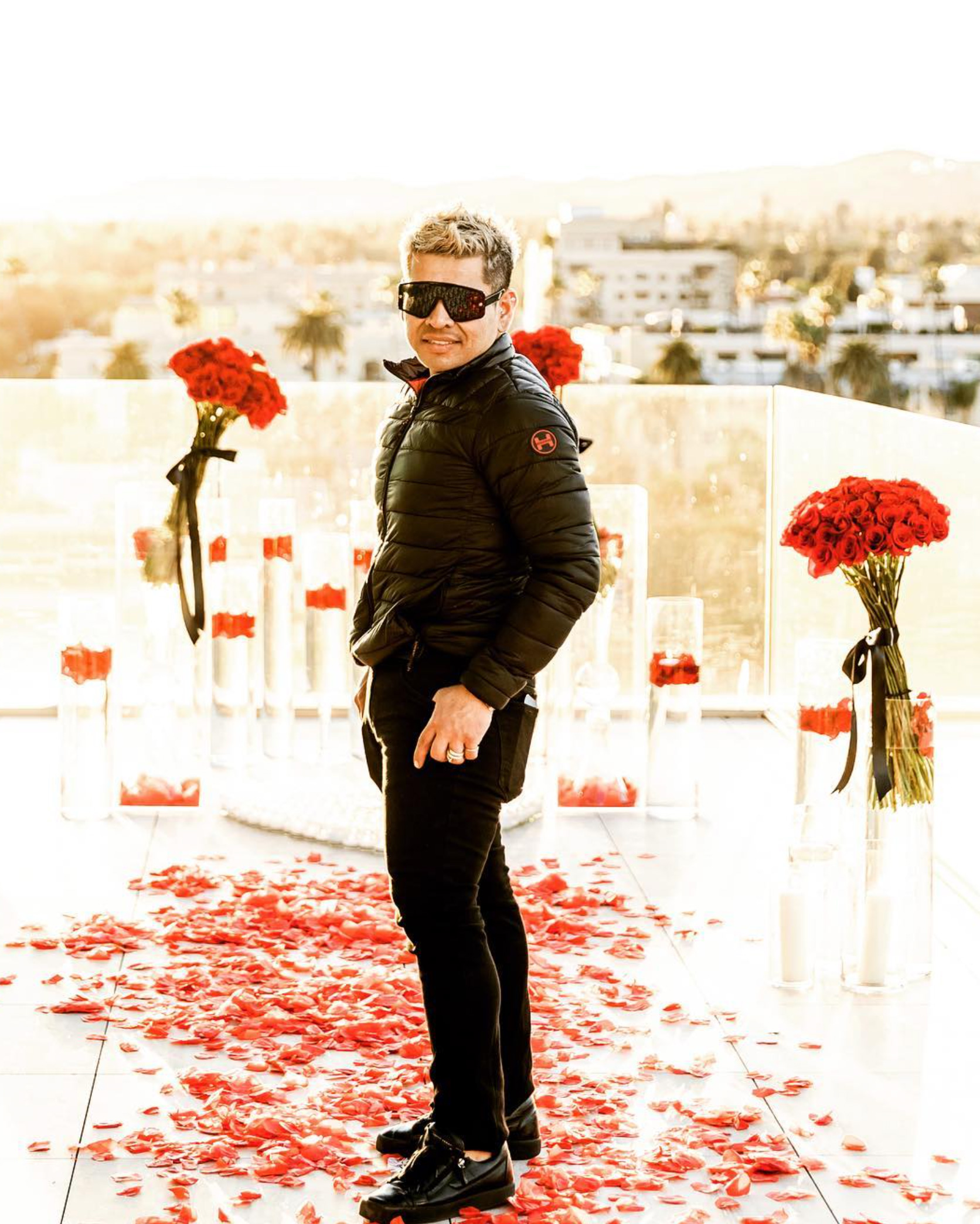 Jorge Ortega, Founder & Creative Florist at Creative Floral Designs, surrounded by romantic red rose installations
