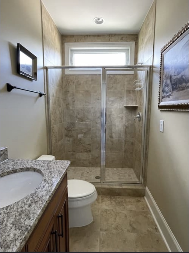 Custom tiled walk-in shower with sliding glass doors and window