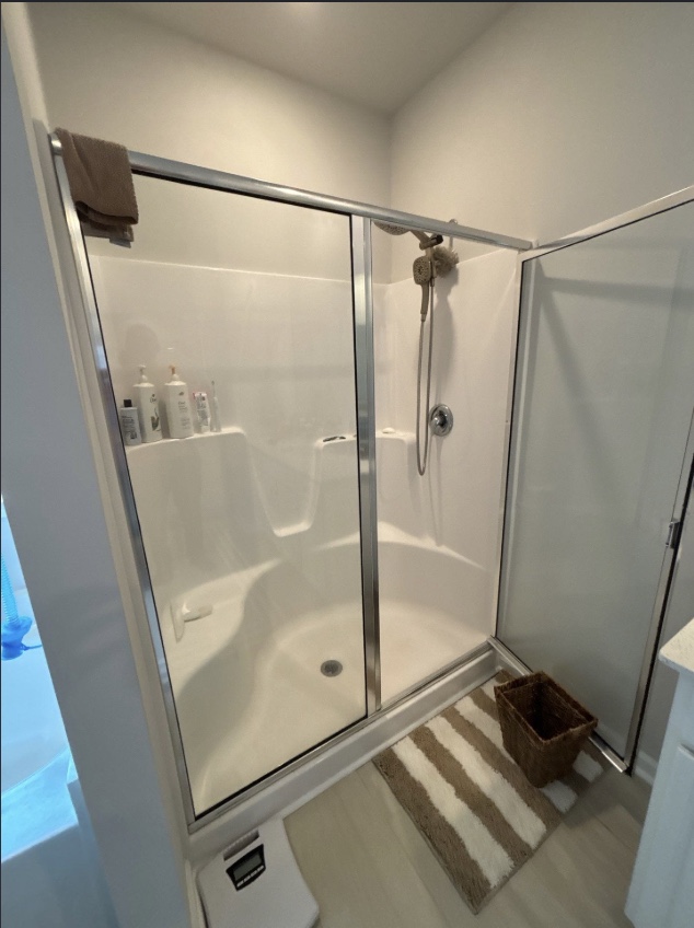 One-piece shower unit with molded seating and sliding glass door