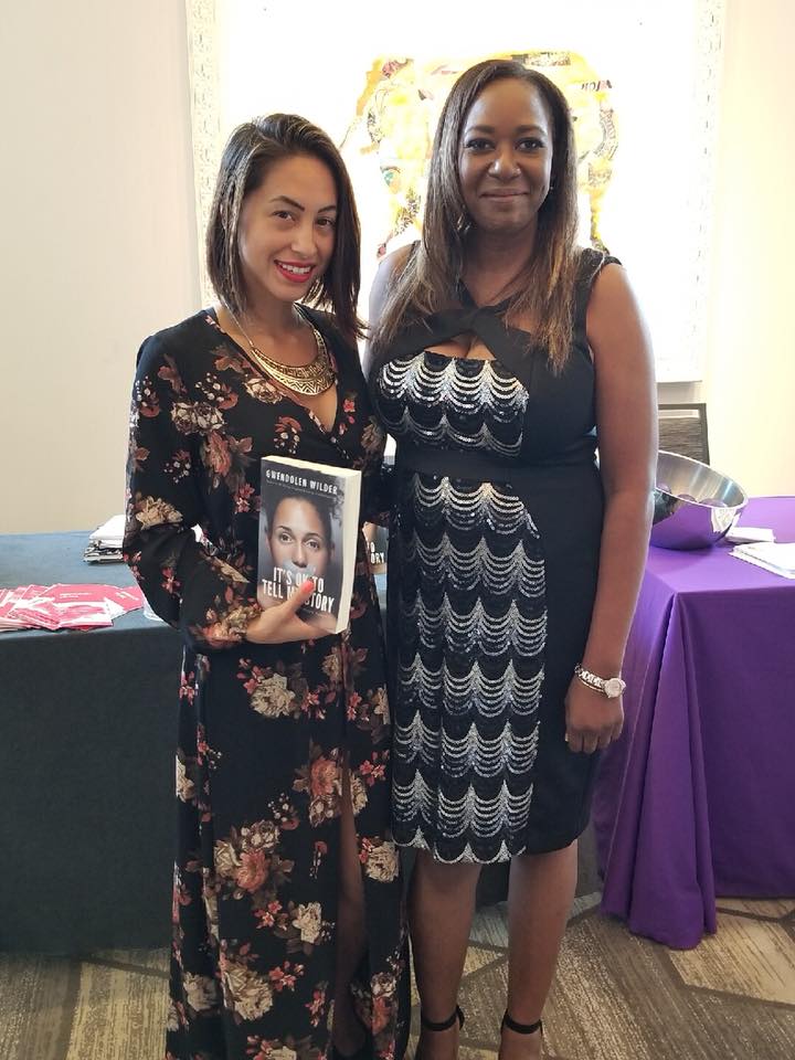 Gwendolen Wilder in an elegant dress standing alongside a woman holding a copy of It's OK to Tell My Story