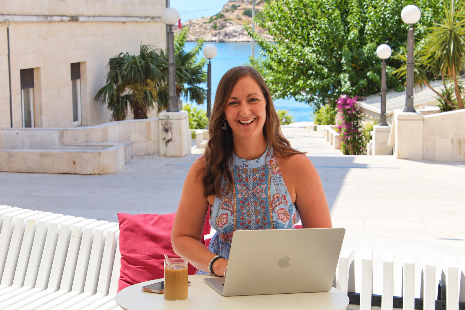 Harmony Jade working with laptop in sun-kissed luxury retreat setting