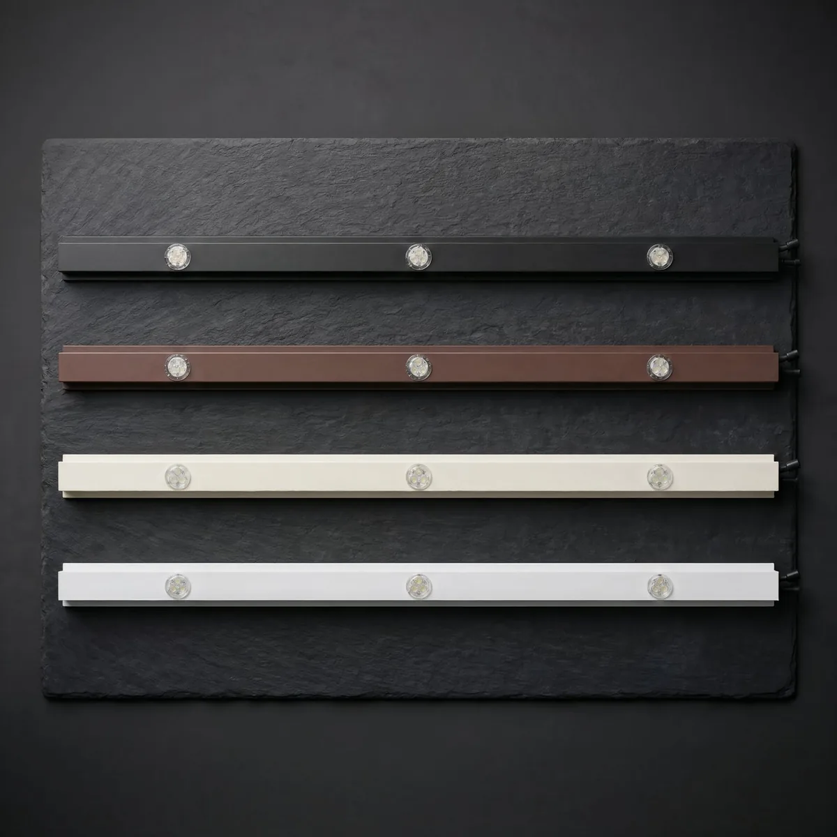 Finished aluminum tracks with seated round RGBW LED puck modules shown in multiple color finishes.