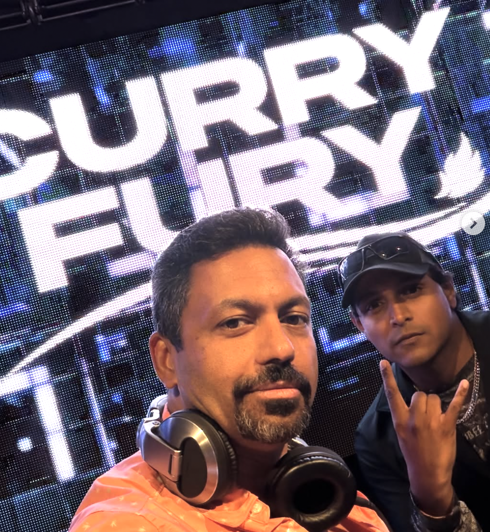 Curry Fury duo GHANDI and Techno Dad in front of the huge illuminated CURRY FURY stage LED screen
