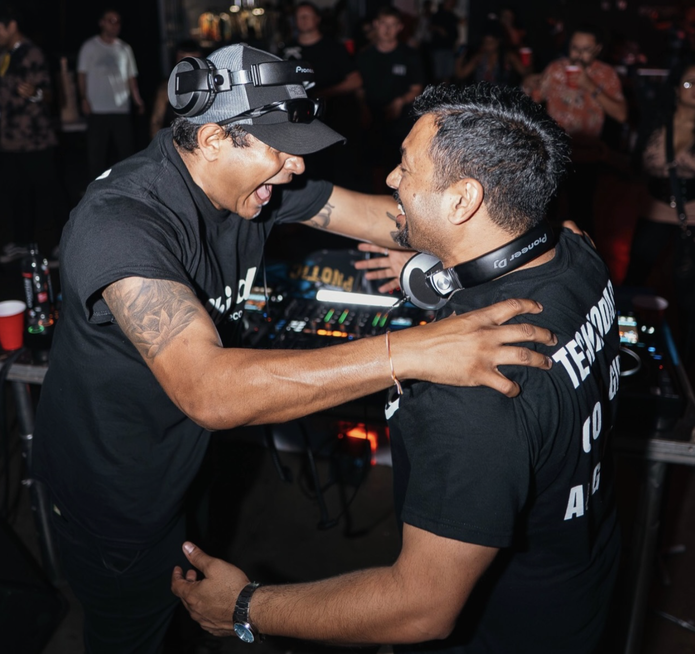 Curry Fury (GHANDI and Techno Dad) celebrating behind the DJ booth during a live set