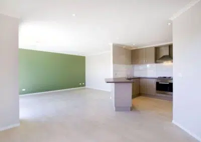 Spacious open plan living and kitchen area with green feature wall