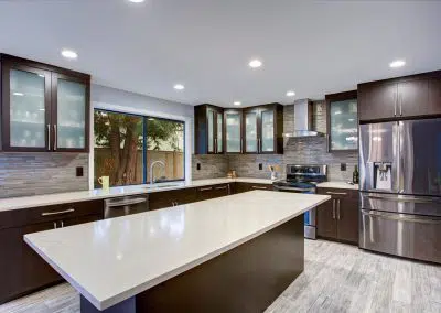 Modern dark timber kitchen with white quartz island benchtop and stainless steel appliances