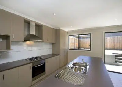 Contemporary kitchen renovation with island sink, gas cooktop and outdoor patio view