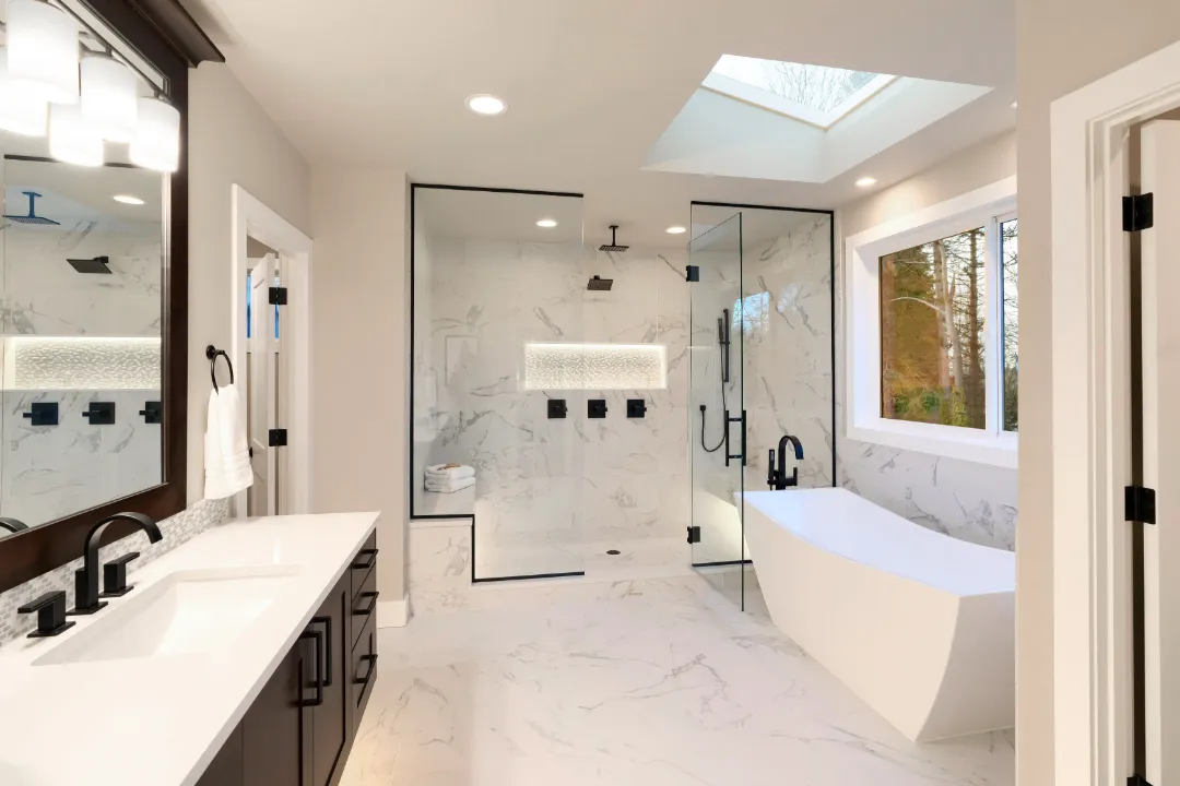 Luxury master bathroom renovation with marble finishes, skylight and freestanding tub
