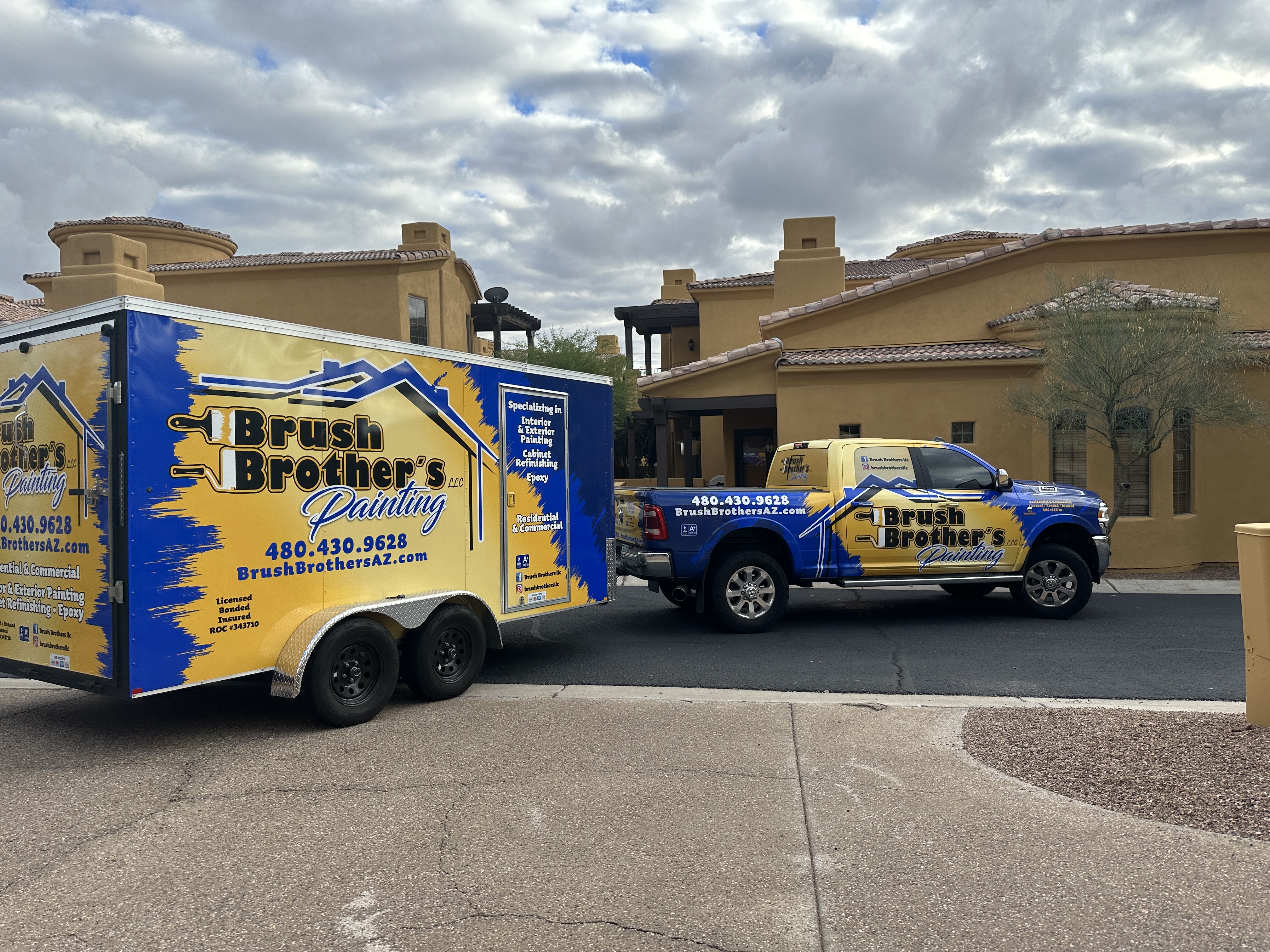Brush Brother's Painting custom wrapped RAM truck and dual-axle equipment trailer on a residential Arizona street