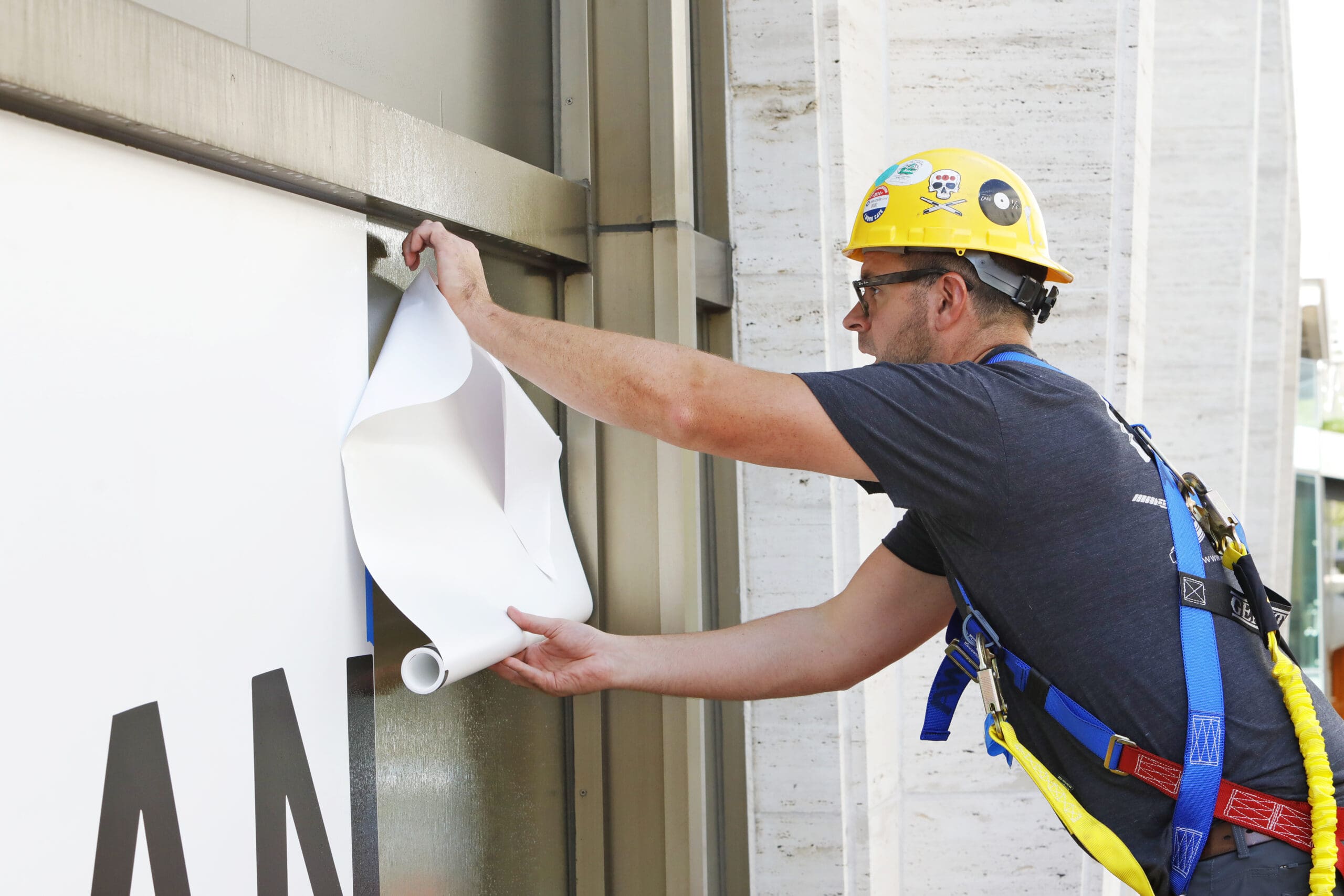 Architectural graphics installer on lift, photographed by Howell Studios in New York
