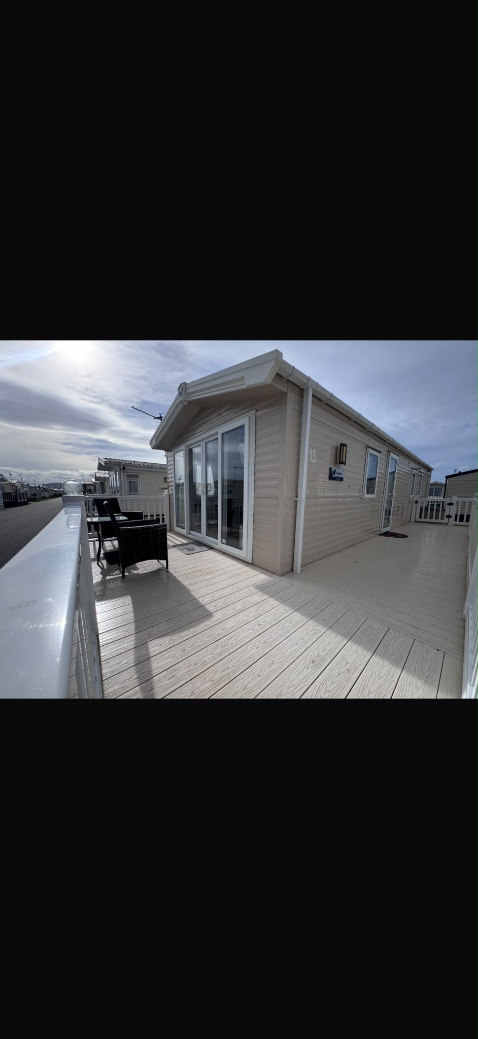 View along the timber decking beside the caravan with outdoor seating