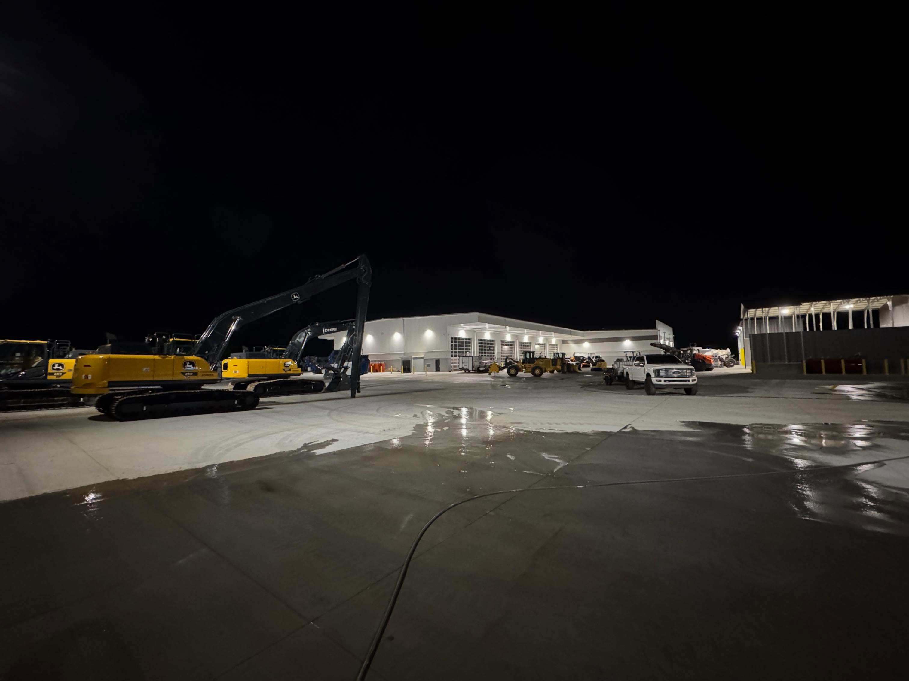 Commercial pressure washing concrete pad and equipment lot at night in Upstate SC