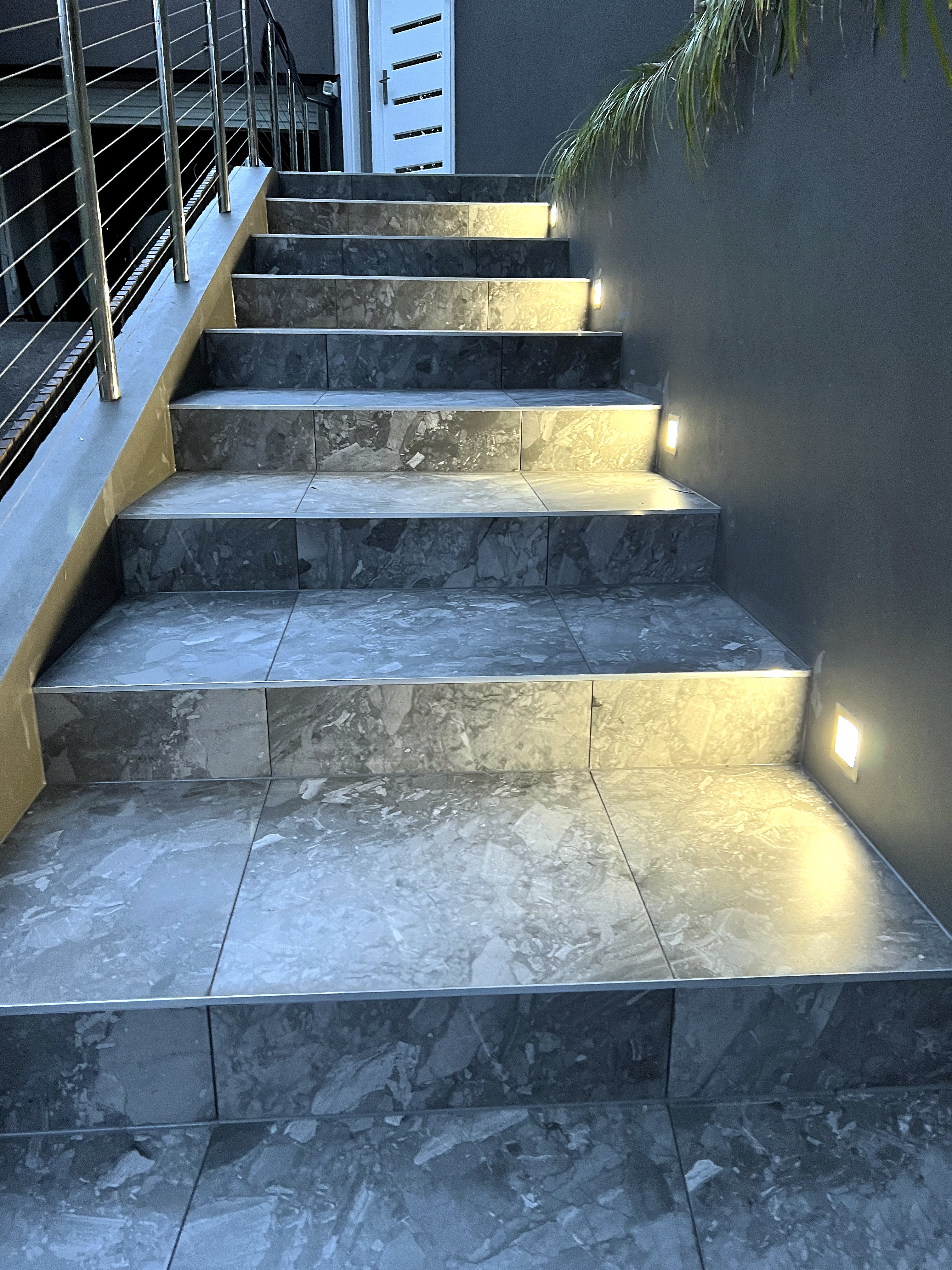 Tiled outdoor steps with integrated step lighting by LYY Tiling & Waterproofing