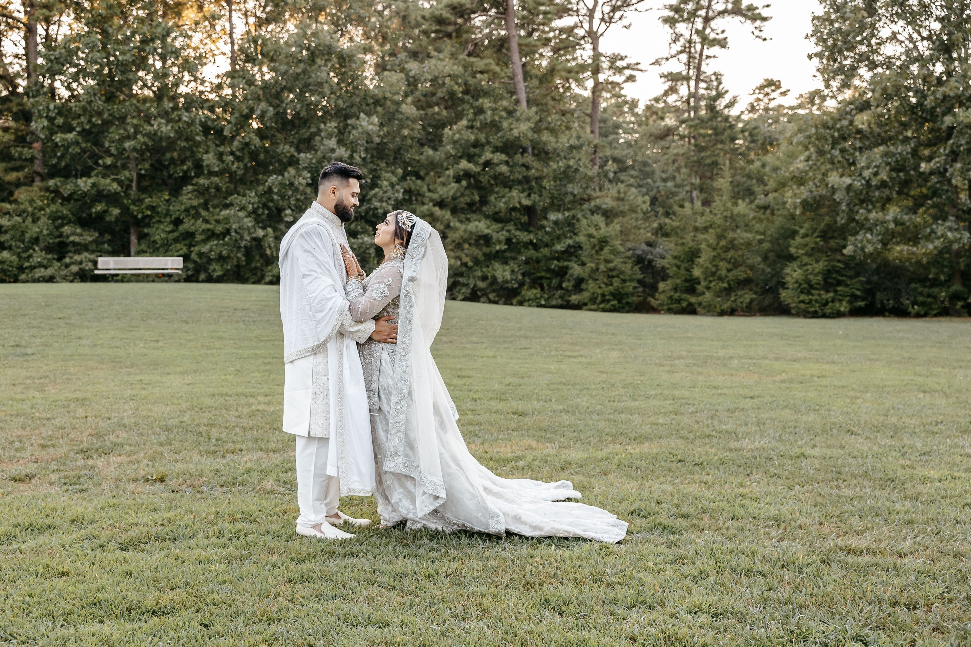 Bride and groom in traditional wedding attire in a scenic outdoor park