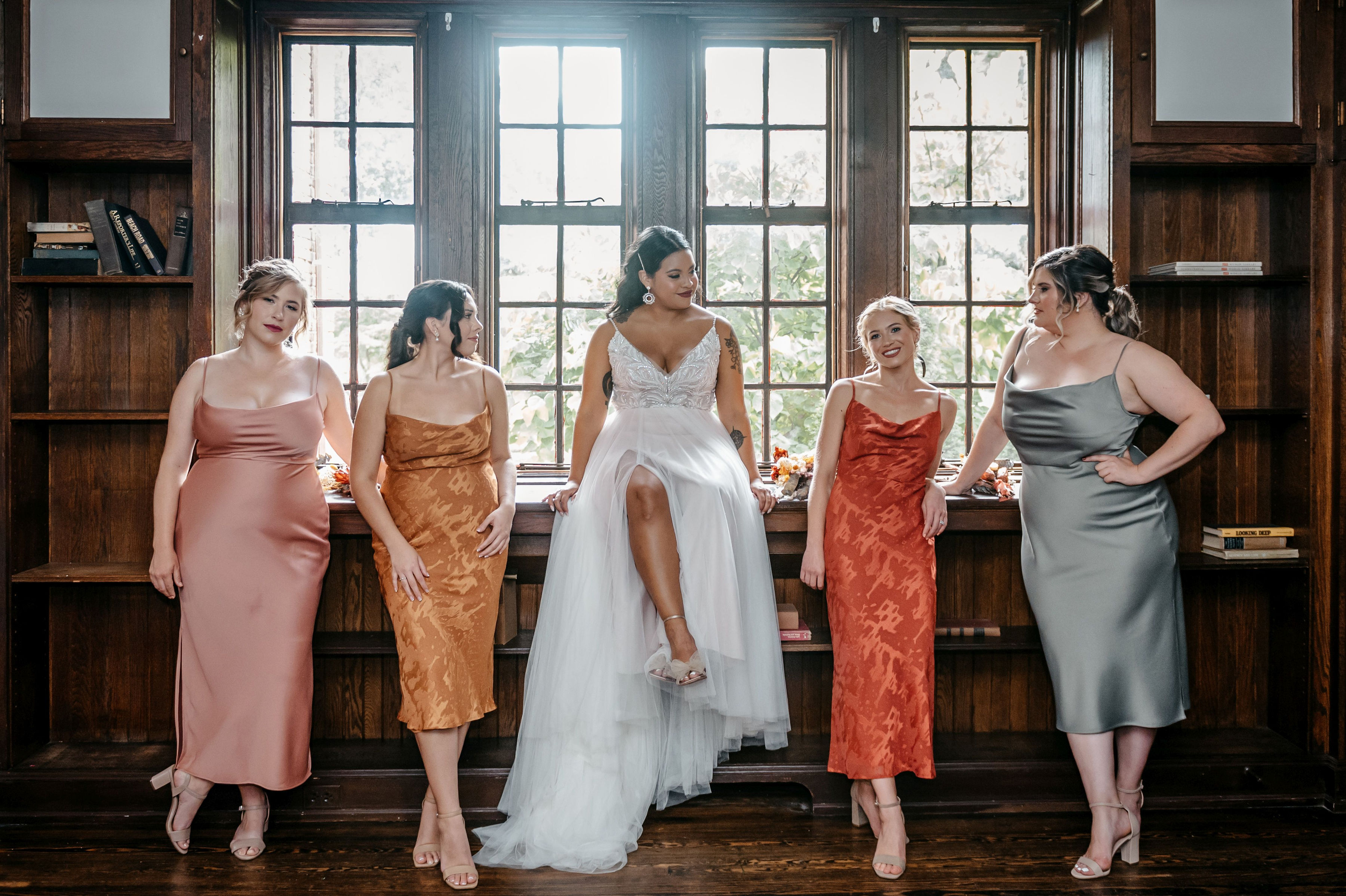 Bride and bridesmaids posing in front of library window