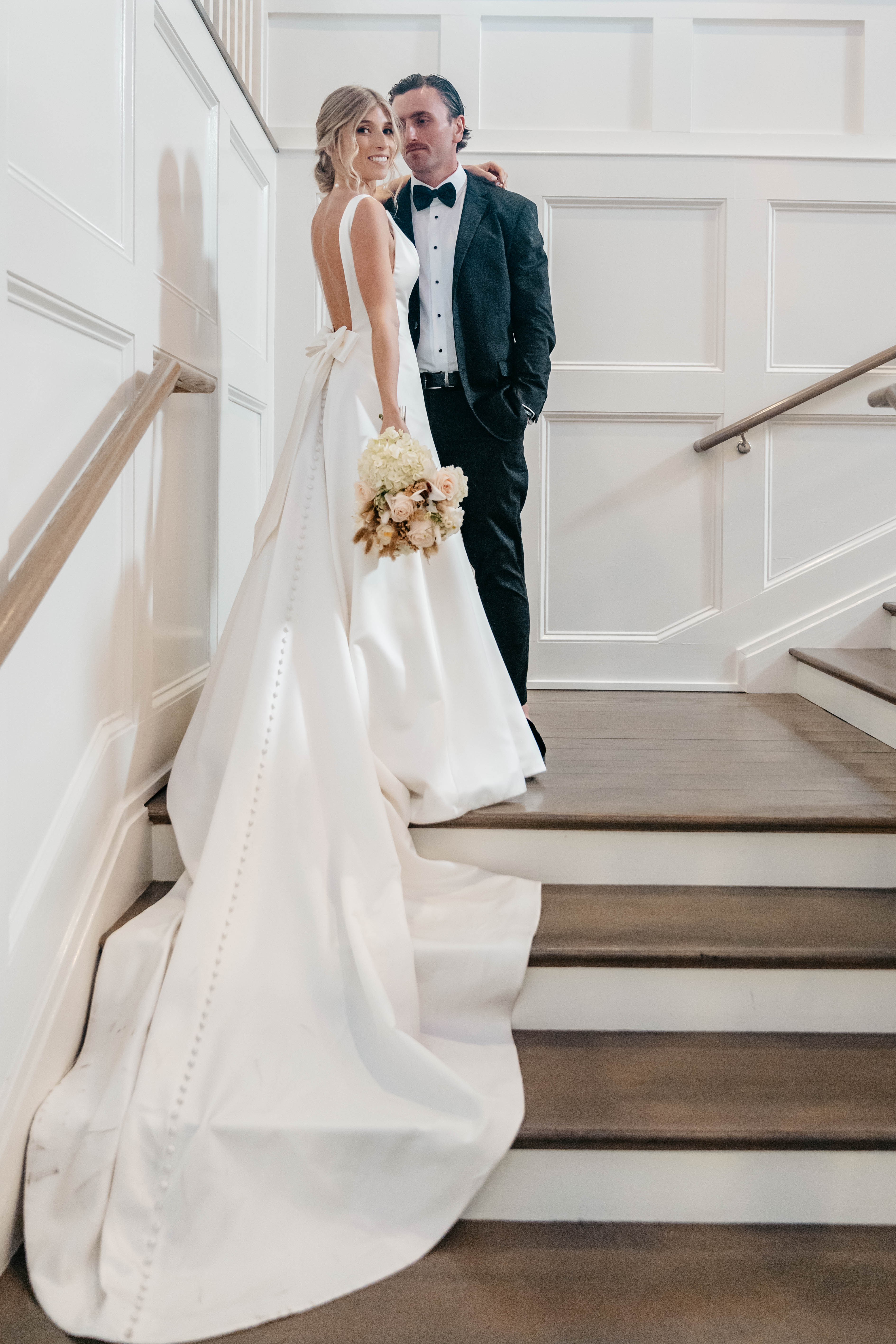 Bride and groom on staircase with cascading bridal gown train