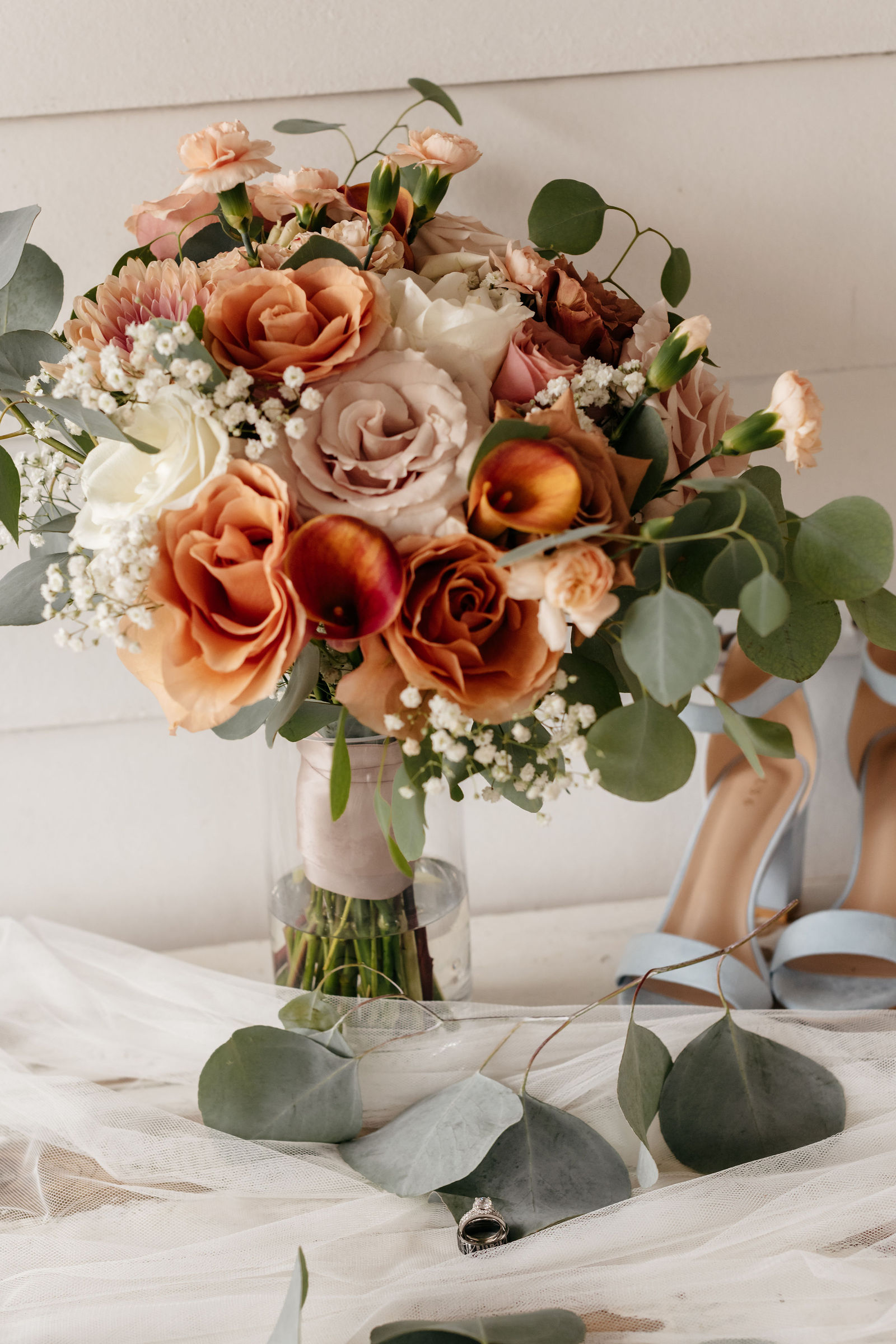 Terracotta and peach bridal bouquet with eucalyptus and wedding details