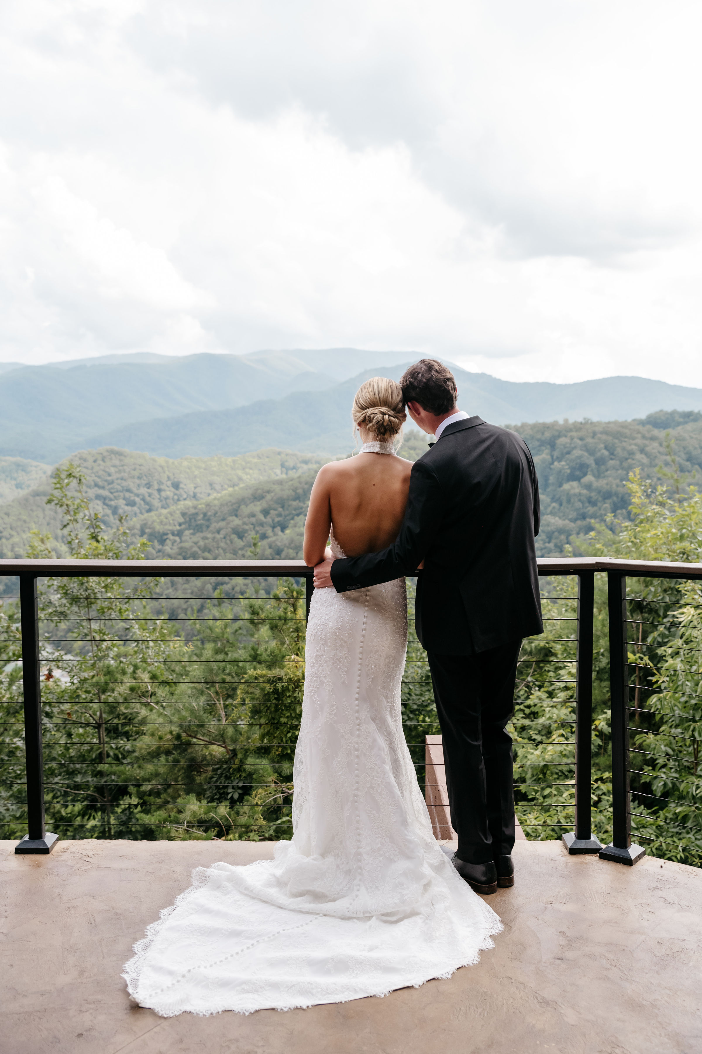 Bride and groom overlooking panoramic mountain views from scenic overlook