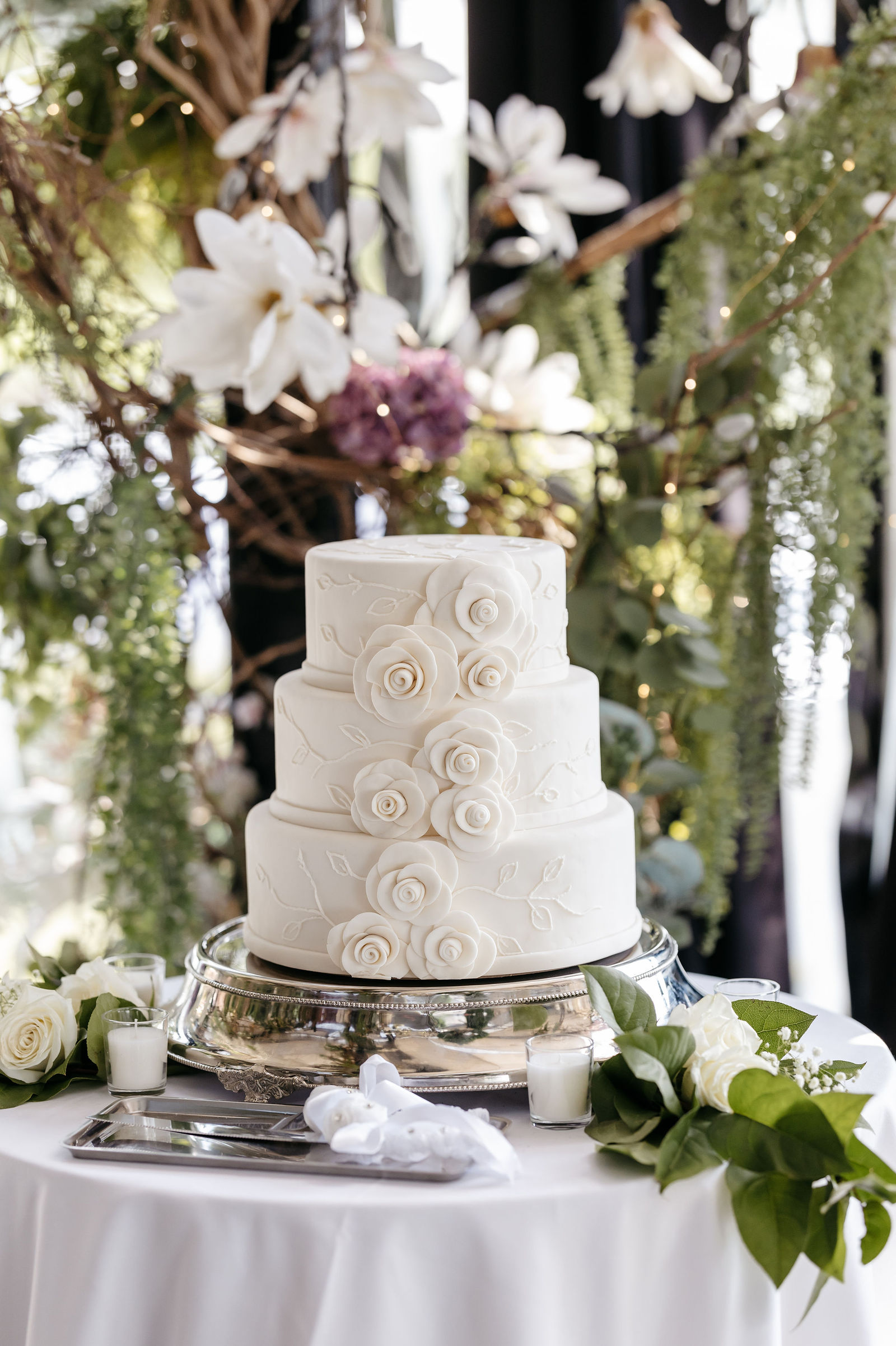 Elegant three-tier white wedding cake adorned with delicate sugar roses