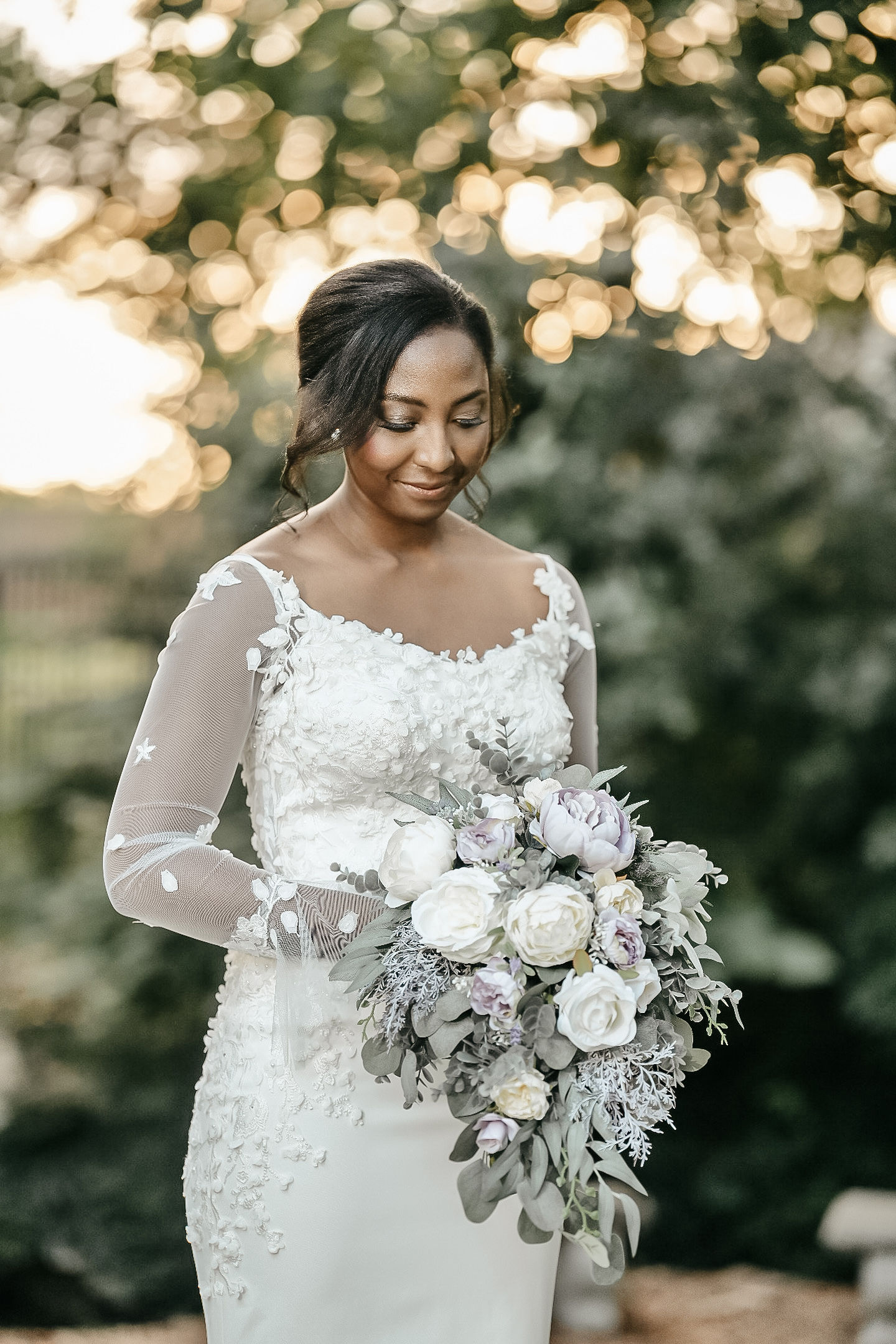 Bride smiling looking down holding floral bouquet