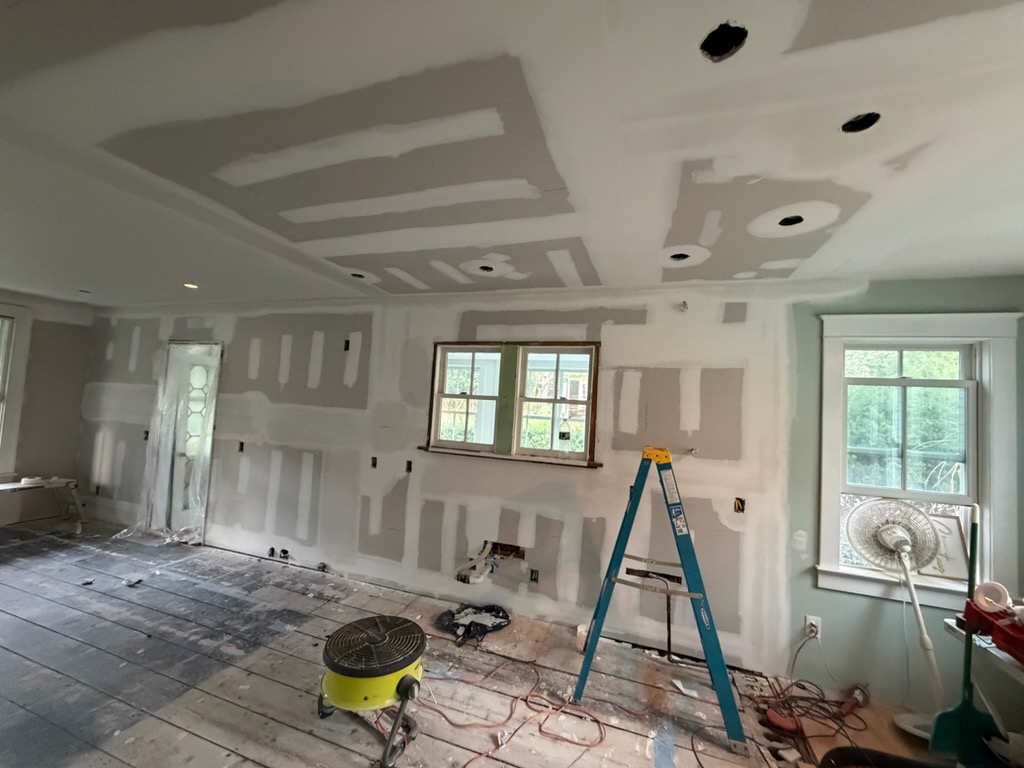 Precision Sheetrock installation and multi-coat Level 5 taping in progress